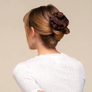 Person wearing the Satin Rosette Medium Flat Cloud Clip in Chocolate in their hair for an elegant updo