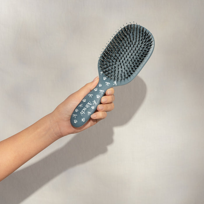 Hand holding Kitsch Coastal Blue Print Smooth & Polish Brush showing vegan boar and nylon dual bristles