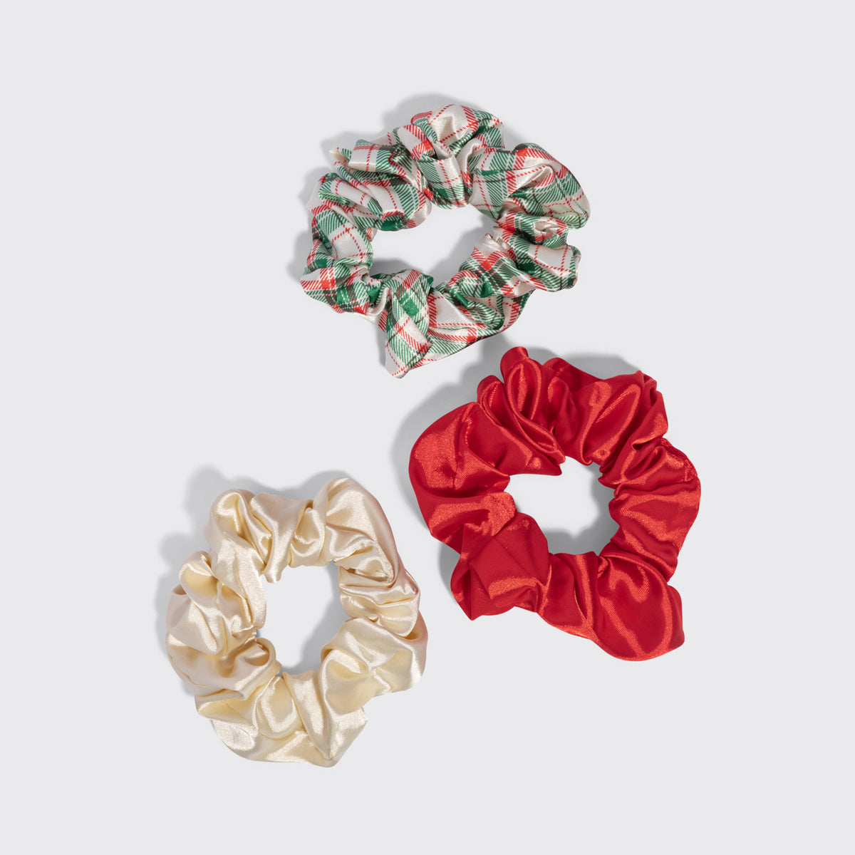 KITSCH Red & Gold Holiday Scrunchies 3pc Set — the red, ivory and plaid scrunchies laid out separately on a grey background — Helps minimize creasing and breakage — gentle everyday wear