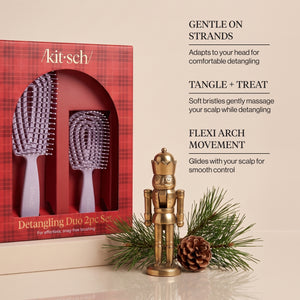 KITSCH Soft Violet Detangling Duo 2pc Set — infographic of the red plaid retail box with the soft violet full-size and mini flexi brushes beside a brass nutcracker, pine branch and pine cone, with callouts Gentle on Strands, Tangle + Treat and Flexi Arch Movement — Includes full-size and mini brushes for easy detangling at home or on the go — gently detangles wet or dry hair for smoother, more manageable strands