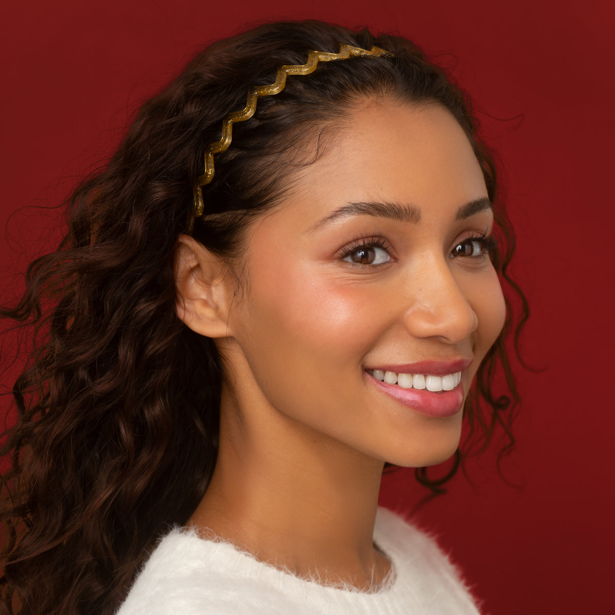 KITSCH Gold & Red Zig Zag Headbands 2pc Set — model with curly hair wearing the gold zigzag headband swept back from her face — Comfortable enough for day-to-night wear — day-to-night holiday looks