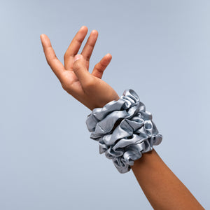 KITSCH Haze Blue Satin Sleep Scrunchies 5pc Set — stack of haze blue satin scrunchies worn on the wrist