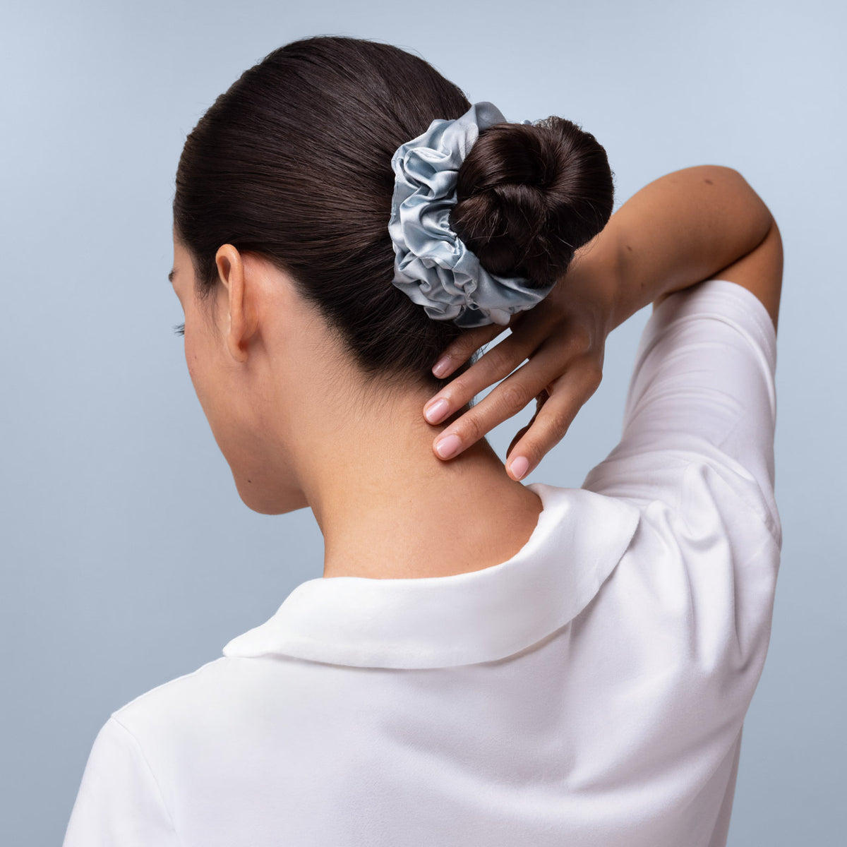 KITSCH Haze Blue Satin Sleep Scrunchies 5pc Set — back view of model with a sleek low bun secured by a haze blue satin scrunchie